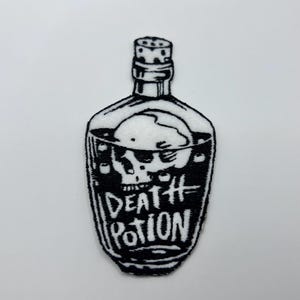 May include: Black and white patch featuring a bottle with a skull inside. The bottle has the words "DEATH POTION" written on it. The patch is likely for clothing or accessories.