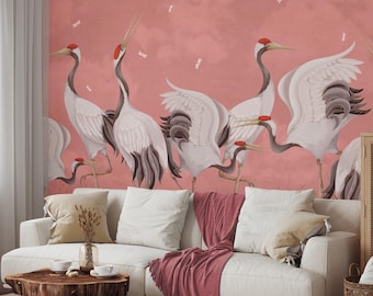 May include: A pink wall mural with a design of white cranes with red accents. The cranes are in a variety of poses, some with their wings spread and some with their heads held high. The mural is a beautiful and elegant addition to any home.
