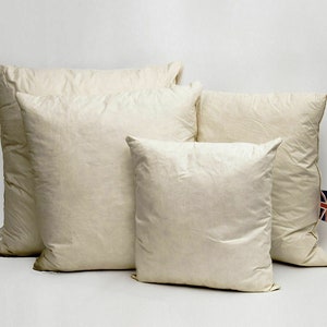 May include: Four white pillow inserts of different sizes. The pillows are made of a soft, natural material and are perfect for adding comfort and support to your bed or sofa.
