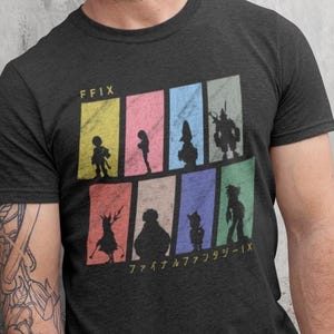 Puede incluir: Camiseta gris oscuro con un gráfico colorido de personajes de Final Fantasy IX en silueta. El diseño incluye el texto "FFIX" y texto japonés. El gráfico está dividido en bloques rectangulares coloridos.