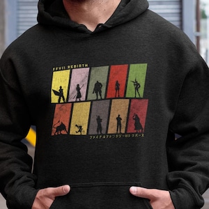 May include: A black hooded sweatshirt featuring a retro-style graphic of characters from the video game "Final Fantasy VII: Rebirth". The graphic is presented in a colourful grid with yellow, orange, red, green, and blue squares. The text "Final Fantasy VII: Rebirth" is printed above the graphic.