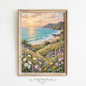 Puede incluir: Pintura enmarcada de un paisaje costero con un camino que conduce a una playa. La obra presenta flores silvestres, un océano turquesa y un cielo al atardecer. El marco es de color claro y neutro. El texto "Artly Nest Prints" está en la parte inferior.