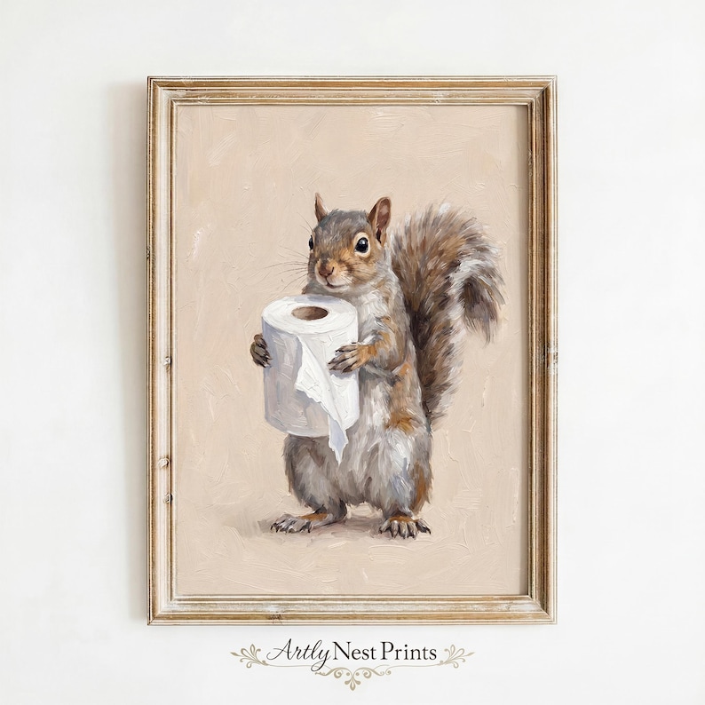 May include: A framed print featuring a detailed painting of a squirrel holding a roll of toilet paper. The squirrel is depicted in shades of gray and brown, with a fluffy tail. The background is a soft beige, and the frame is a light brown.