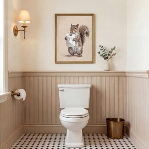 May include: A bathroom scene featuring a white toilet, a gold-framed squirrel art print holding toilet paper, and a brass wastebasket. The walls are painted in neutral tones with a black and white tiled floor. A wall sconce provides soft lighting.