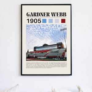 May include: A framed poster featuring the text "GARDNER WEBB 1905" above a photograph of a university athletic complex. The poster includes color swatches of blue, light blue, light gray, and maroon. The poster has a black frame.