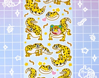 May include: A sheet of stickers featuring various cartoon leopard geckos in different poses. The stickers are on a white background with yellow stars and pink hearts. The text "hecko gecko" is at the top of the sheet.