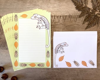 Op de afbeelding: Een set van 10 groene en witte briefkaarten met een gekko-hagedisontwerp. De kaarten tonen een gekko-hagedis met een lange staart, bruine en witte bladeren en bruine krekels. De kaarten zijn gestreept om op te schrijven.