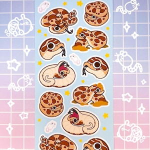 May include: A sheet of 12 stickers featuring cartoon illustrations of snakes in various poses. The stickers are on a light blue background with white stars and the text "drama hog" at the top.
