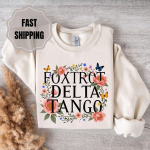 Foxtrot Delta Tango-sweater: boodschap anti-Trump-verzet