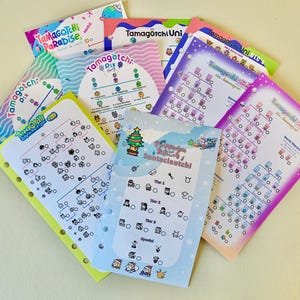 Op de afbeelding: Een verzameling kleurrijke Tamagotchi-gidsen en -kaarten. De gidsen bevatten verschillende ontwerpen, waaronder grafieken, illustraties en tekst. Het kleurenpalet omvat blauw, roze, groen en geel. De tekst bevat "Tamagotchi Pix", "Tamagotchi Uni" en "Santacleutchi".