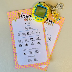 May include: A yellow handheld digital pet toy with a screen, a keychain with cartoon characters, and two pink and yellow polka dot cards with Japanese text and character illustrations. The cards have a diagram of characters.