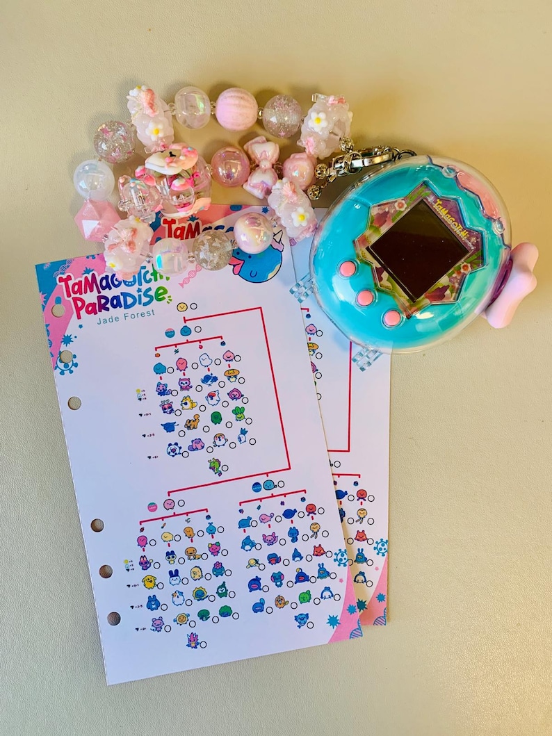 May include: A teal Tamagotchi virtual pet with a pink bow, next to a beaded bracelet with pink and clear beads. Two sheets of paper with a chart of Tamagotchi characters are also present.