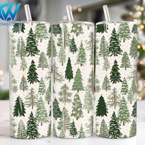 Könnte beinhalten: Drei weiße Edelstahlbecher mit grünen und weißen Weihnachtsbaummotiven. Die Becher haben transparente Deckel und Strohhalme.