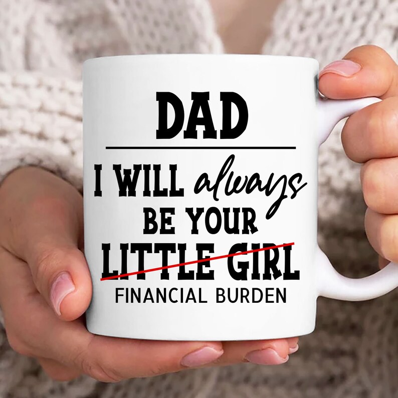 May include: White ceramic mug with black text that reads "DAD I WILL always BE YOUR LITTLE GIRL FINANCIAL BURDEN" with the word "GIRL" crossed out.