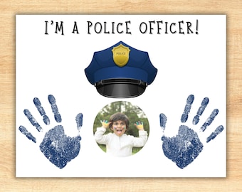 Puede incluir: Una tarjeta blanca con el texto "¡Soy un policía!" impreso en negro. Un gorro de policía azul con una insignia dorada está sobre dos huellas de manos azules. Una foto de un niño con pintura colorida en la cara y las manos está en un círculo en el medio de la tarjeta.