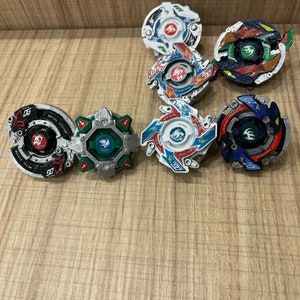 Può includere: Una collezione di sei trottole colorate con diversi design e colori, tra cui rosso, blu, verde, bianco e nero. Le trottole sono realizzate in metallo e plastica e presentano una varietà di caratteristiche, come un telaio in metallo, una punta in plastica e un disco rotante.