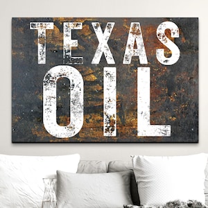 May include: A rectangular wall art piece featuring the words TEXAS OIL in large, distressed white capital letters. The background has a dark, weathered, and rusted metal texture with patches of brown, black, and orange oxidation throughout.