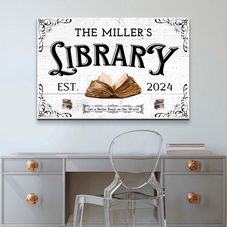 May include: White wooden sign with black text that reads "The Miller's Library Est. 2024 Get a Better Read on the World". The sign features a decorative floral design and an illustration of an open book.