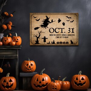 May include: A rectangular wall sign with a tan, weathered background featuring black silhouettes of a witch on a broom, bats, ghosts, a tree, a scarecrow, and pumpkins. The text reads: OCT. 31 WHEN THE GHOSTS, GHOULS & MONSTERS COME OUT TO HAUNT.