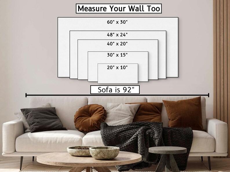 May include: A white sofa with brown throw pillows and a black throw blanket. The wall behind the sofa has a diagram showing different sizes of wall art with the text "Measure Your Wall Too" and "Sofa is 92" inches.