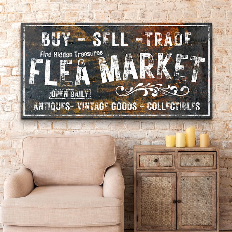 May include: A vintage-style sign with a rusty metal background and white lettering that reads "BUY - SELL - TRADE Find Hidden Treasures FLEA MARKET OPEN DAILY ANTIQUES - VINTAGE GOODS - COLLECTIBLES".