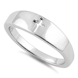 May include: A silver band ring with a cut-out cross design.