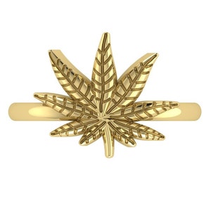 May include: A gold ring with a detailed marijuana leaf design.