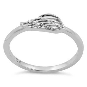 May include: Sterling silver ring featuring a detailed wing design. The ring is simple and elegant, ideal for everyday wear.