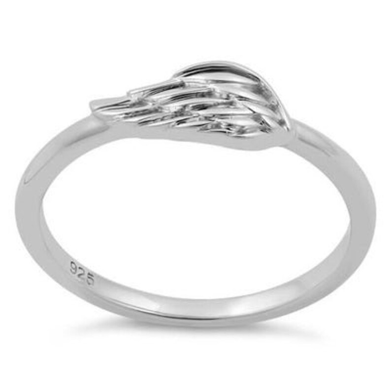 May include: Sterling silver ring featuring a detailed wing design. The ring is simple and elegant, ideal for everyday wear.