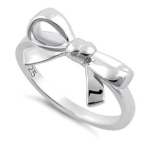 May include: Sterling silver ring featuring a bow design. The bow is positioned in the centre of the ring and is crafted from polished silver.