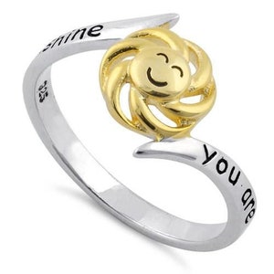 以下が含まれることがあります： 「You are sunshine」と刻まれたバンドに、金の太陽のデザインが施された銀のリングです。