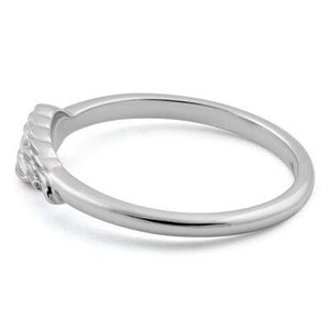May include: A silver band ring with a textured design on the front.