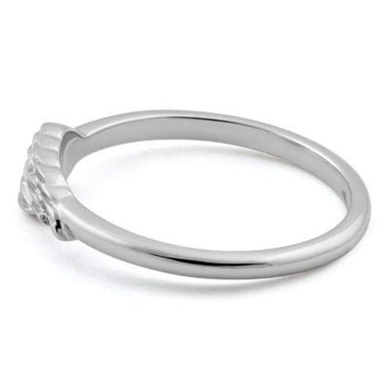 May include: A silver band ring with a textured design on the front.