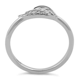 May include: Sterling silver ring featuring a delicate wing design. The wing is detailed with a textured surface and is set at an angle on the band.