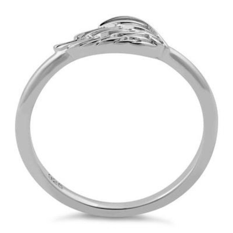 May include: Sterling silver ring featuring a delicate wing design. The wing is detailed with a textured surface and is set at an angle on the band.