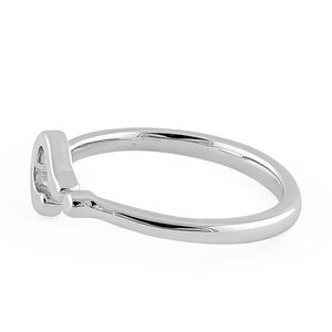 Puede incluir: Un anillo de plata con un dise&ntilde;o simple y curvo. El anillo es liso y pulido.