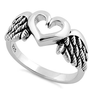 May include: A silver ring featuring a heart-shaped design with open space in the center, flanked by detailed wing accents. The ring is marked with "925" on the band, indicating the metal's purity. The ring is a piece of jewelry.