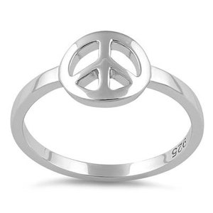 Puede incluir: Un anillo de plata de ley con un símbolo de paz. El anillo es una banda simple con un símbolo de paz en el centro.
