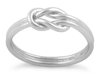 Puede incluir: Un anillo de nudo de plata con un acabado liso y pulido.