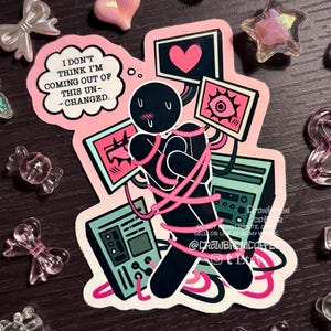 May include: A die-cut sticker featuring a black stick figure wrapped in pink cables, surrounded by teal computer monitors displaying a heart and an eye. A speech bubble reads, I DON'T THINK I'M COMING OUT OF THIS UN-CHANGED. The design includes pink accents.