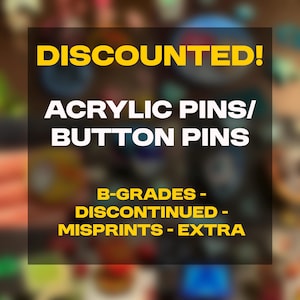May include: Image features the text "DISCOUNTED!" in yellow, above "ACRYLIC PINS/ BUTTON PINS" in white. Below, it lists "B-GRADES - DISCONTINUED - MISPRINTS - EXTRA" in yellow. The background is a blurred mix of colors.