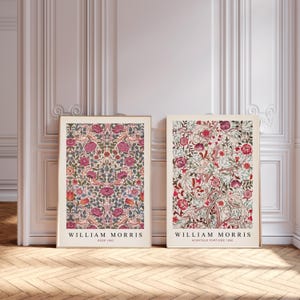 May include: Two framed prints of floral patterns by William Morris. The left print features a pink and green floral pattern with the text "William Morris Rose 1883". The right print features a red and green floral pattern with the text "William Morris Acanthus Portiere 1883".