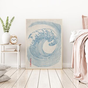 Puede incluir: Un dibujo en l&iacute;nea azul y blanco de una gran ola rompiendo, con el texto japon&eacute;s "神奈川沖浪裏" en rojo en el lado derecho de la imagen.