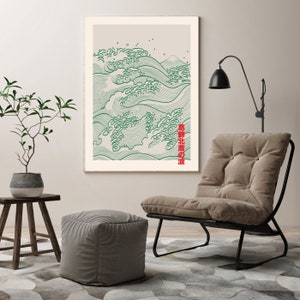 May include: A framed print of a green and white wave design with the Japanese text "波 北部 の" in red. The print is hanging on a wall above a brown armchair with a black metal frame.