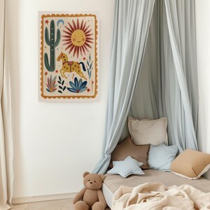 Puede incluir: Una l&aacute;mina de arte mural rectangular que presenta un caballo amarillo central con silla de montar, un sol sonriente, un cactus verde alto y varios elementos bot&aacute;nicos azules y rojos, todo dentro de un borde festoneado color mostaza.