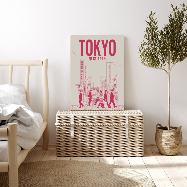 K&ouml;nnte beinhalten: Eine rosa und wei&szlig;e Illustration einer Stra&szlig;enszene in Tokio, Japan. Die Illustration zeigt Personen, die &uuml;ber einen Zebrastreifen gehen, Geb&auml;ude und Schilder in japanischer Sprache. Der Text "TOKYO" und "東京 JAPAN" ist in rosa oben auf der Illustration gedruckt.