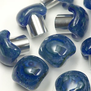 Può includere: Un set di pomelli per armadi in vetro blu con basi in metallo argentato. Il vetro ha un effetto marmorizzato e a spirale.