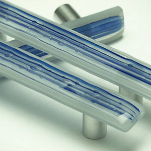 Könnte beinhalten: Zwei gläserne Schranktürgriffe mit einem silbernen Metallsockel. Das Glas ist mit blauen Streifen mattiert.