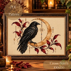 Könnte beinhalten: Ein gerahmtes Kreuzstichmuster mit einem schwarzen Raben auf einem goldenen Halbmond, umgeben von dunkelroten Blättern und kleinen Sternakzenten. Das Design ist auf cremefarbenem Stoff mit dem Text PDF Pattern abgebildet.