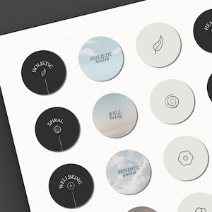 May include: A set of 12 round stickers with various designs and text related to wellness and mindfulness. The stickers feature a variety of colors, including black, white, and light blue. The text on the stickers includes "Holistic Health", "Well Being", "Mindful Quotes", "Spiral", "Natural", "Healing", and "Affirmations".